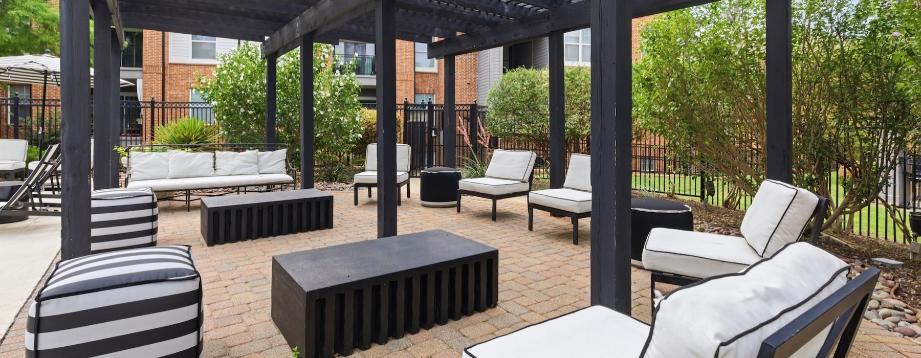 a covered patio with tables, couches and chairs