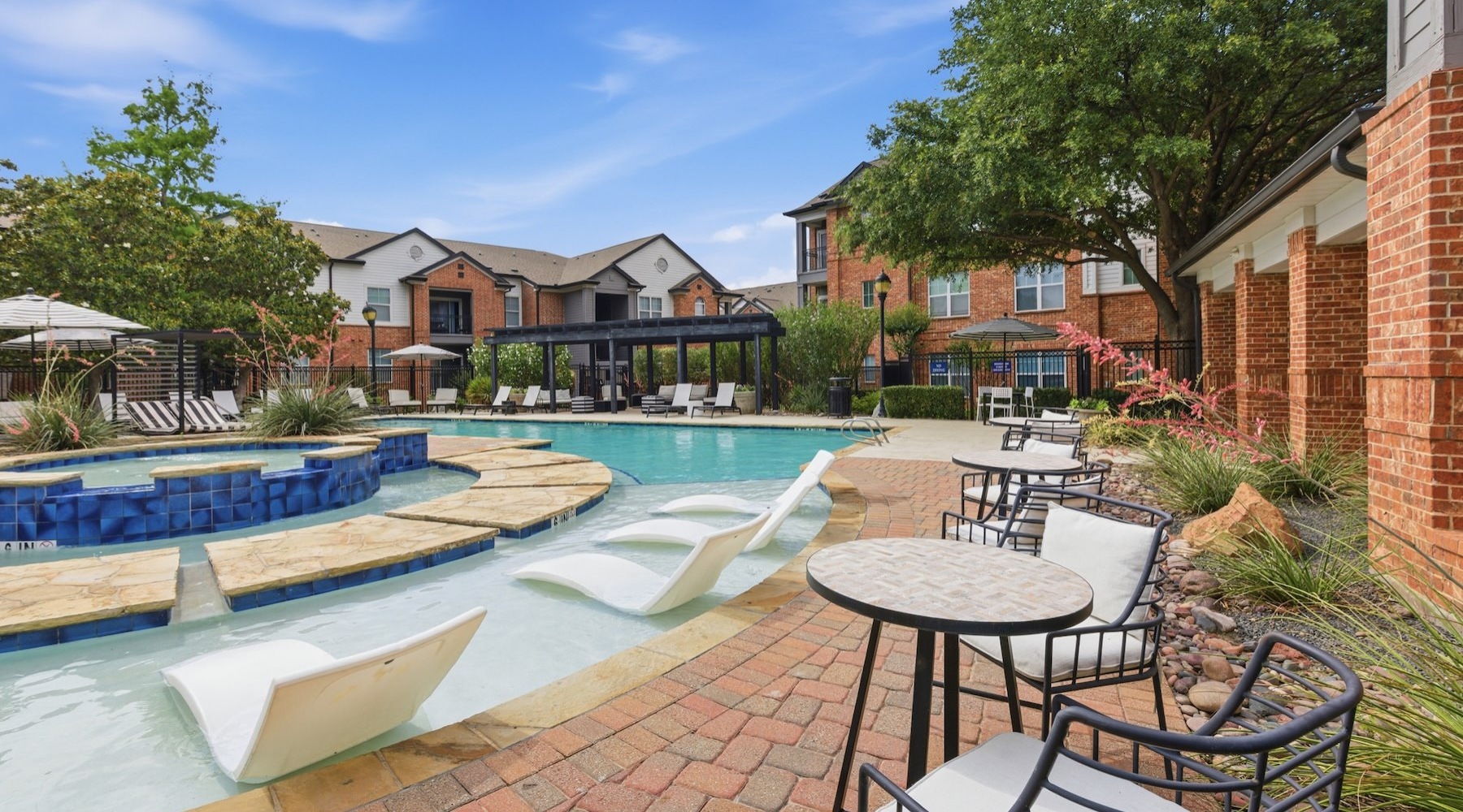 a swimming pool with tables and chairs