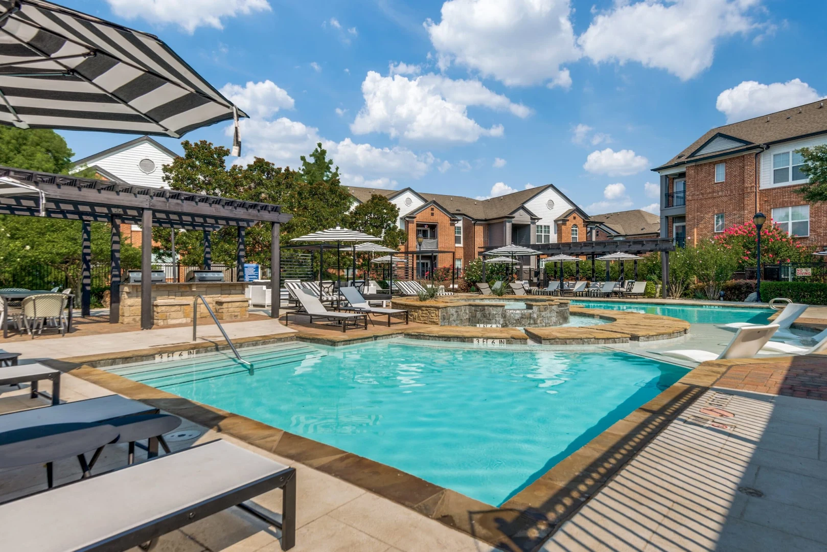 Pool with sundeck, lounge chairs, and clubhouse